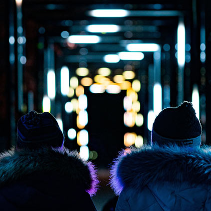 Two people standing in a lit up attraction at the Zoo